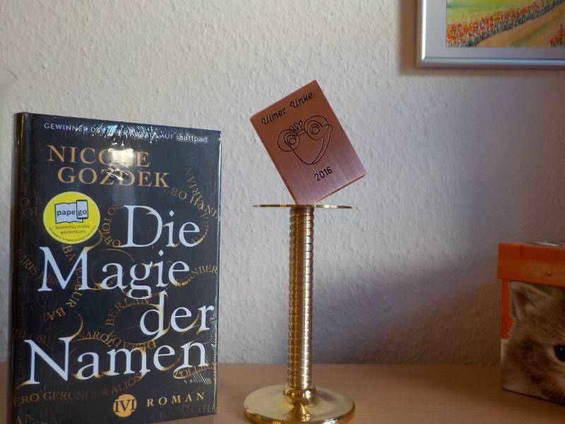 Preis aus Metall neben Buch