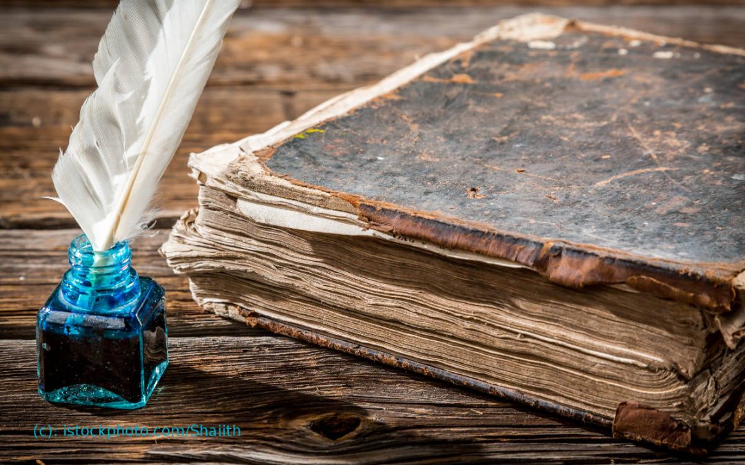altes Buch mit Feder und blauem Tintenfass